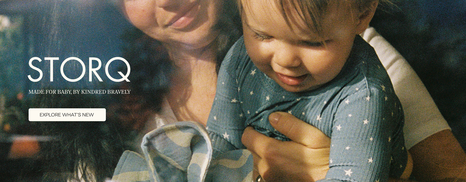 Woman holding baby with copy 'STORQ Made for baby by Kindred Bravely'