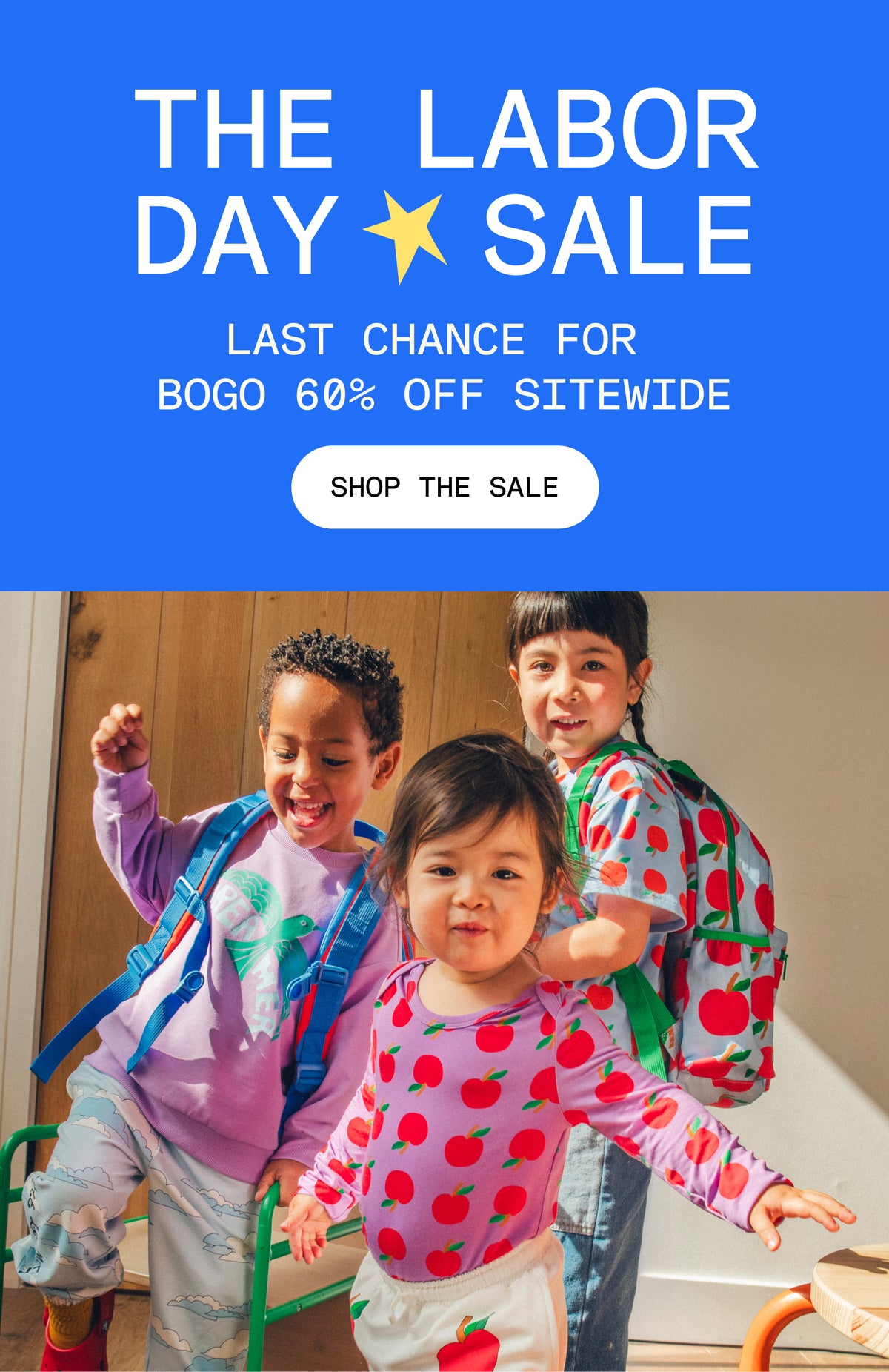 Promotional image with blue background and white text that reads, The Labor Day Sale, Last Chance for BOGO 60% Off sitewide. White button and black text that reads, Shop the Sale. Group image of three models wearing Cool Kid Backpacks, Graphic Tee in Blue Apple, Long Sleeve Bamboo Onesie Two-Pack in Apple, Graphic Sweatshirt in Purple Bird, French Terry Jogger in Blue Clouds and French Terry Jogger in Ivory Apple in a sunlit room.