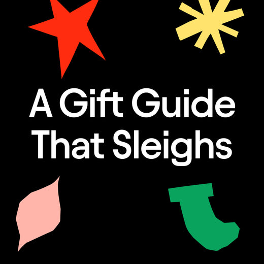 Promotional graphic with the text 'A Gift Guide That Sleighs' in large white letters on a black background, and holiday-themed abstract shapes in red, yellow, pink, green, and black.