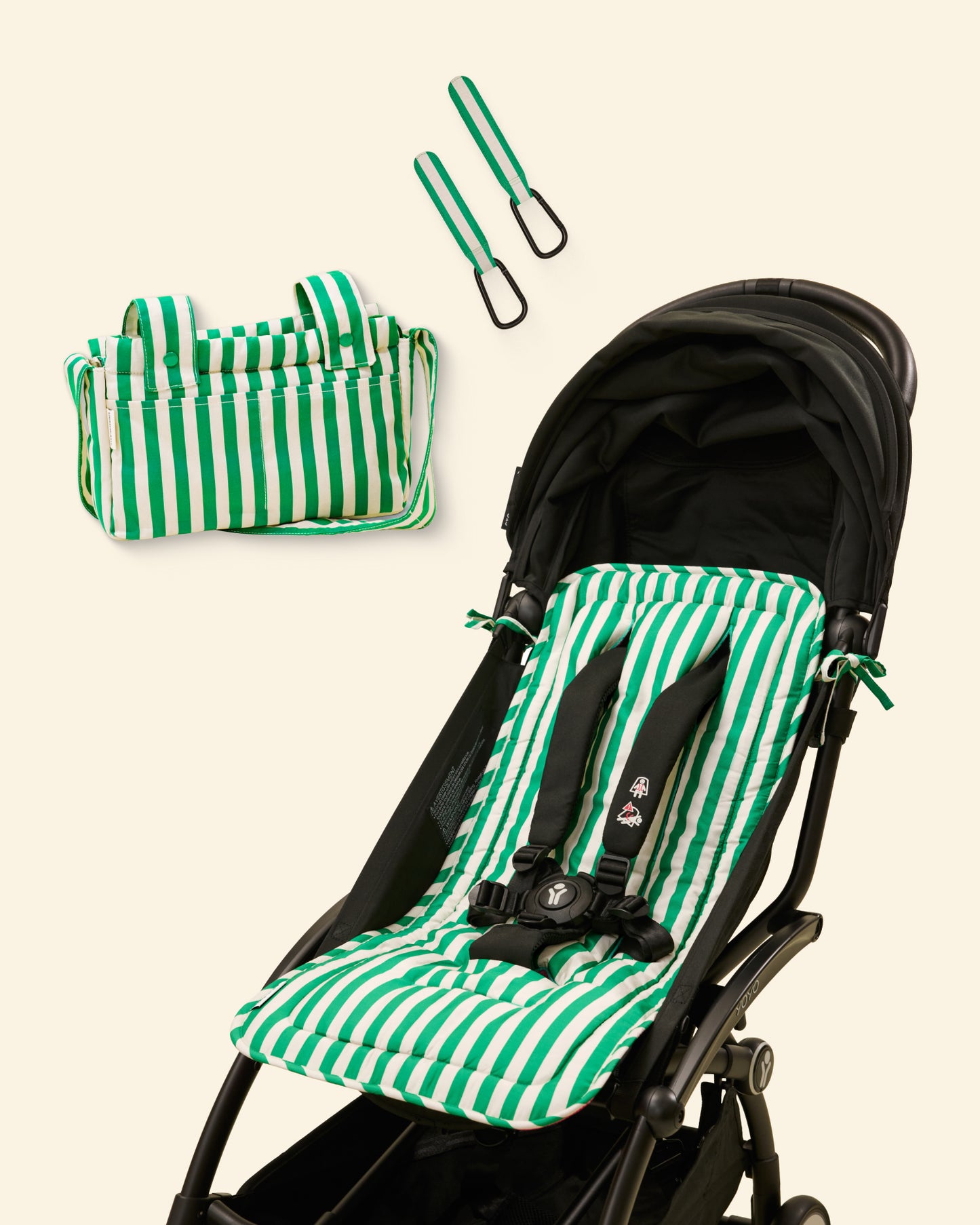 Green and white striped stroller seat cover with matching bag and stroller clip on a light background