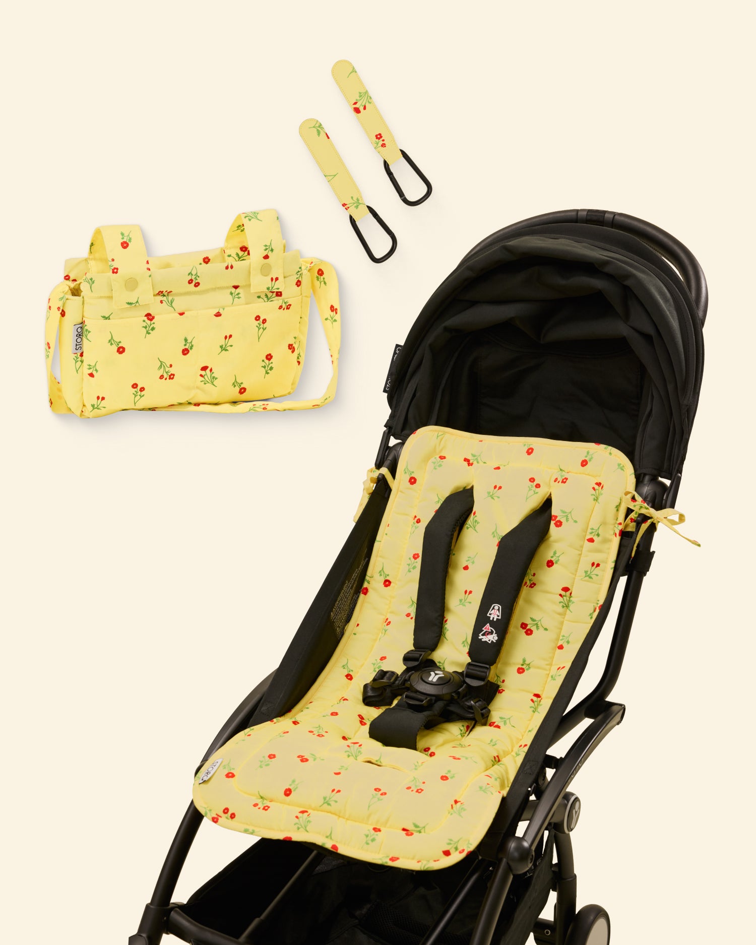 Yellow and red floral patterned stroller seat cover with matching bag and stroller clip on a light background