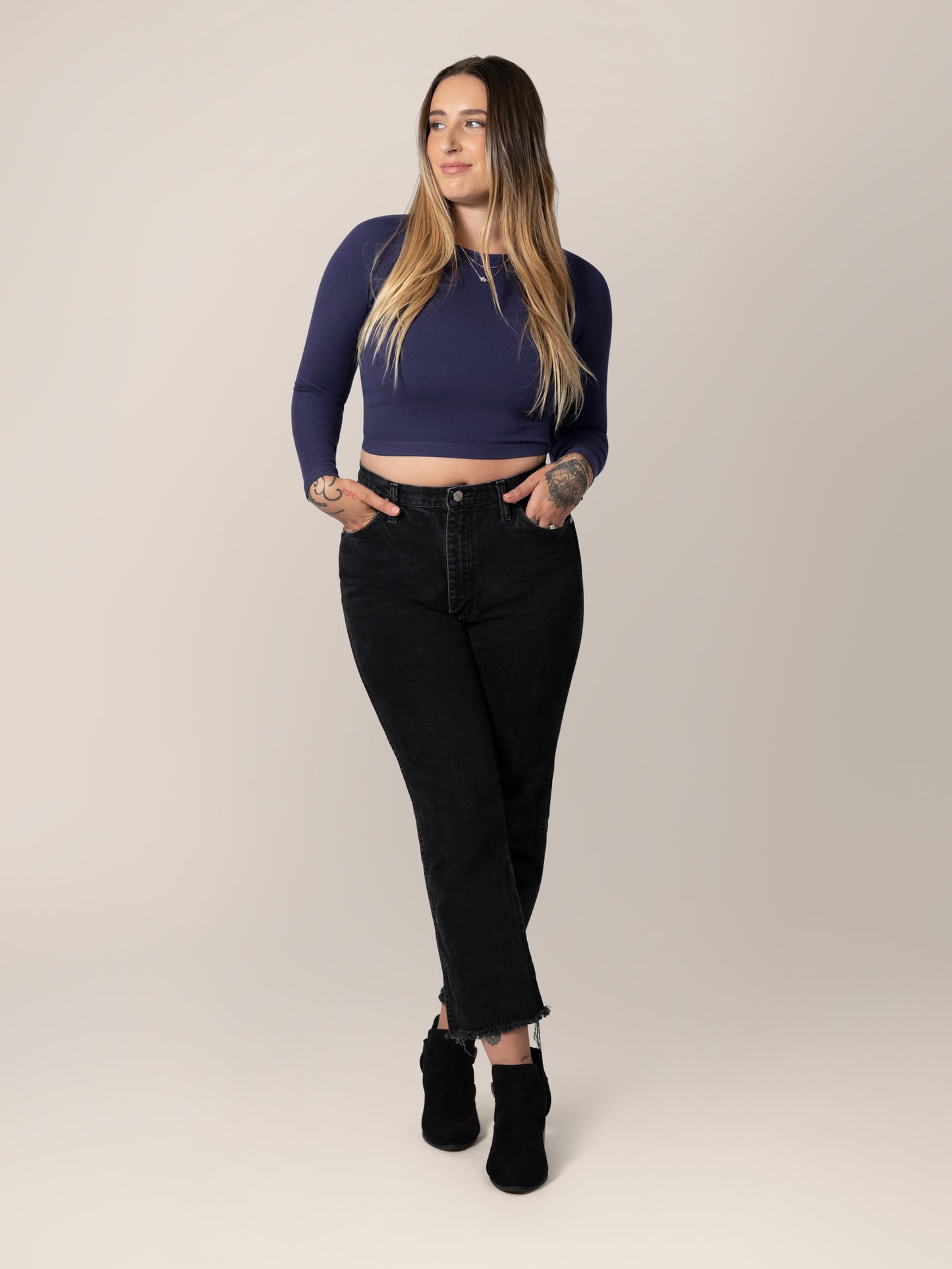Full body view of model wearing the Sublime® Bamboo Maternity & Nursing Cropped Long Sleeve Top in Navy, paired with black cropped jeans with raw hem, and black booties