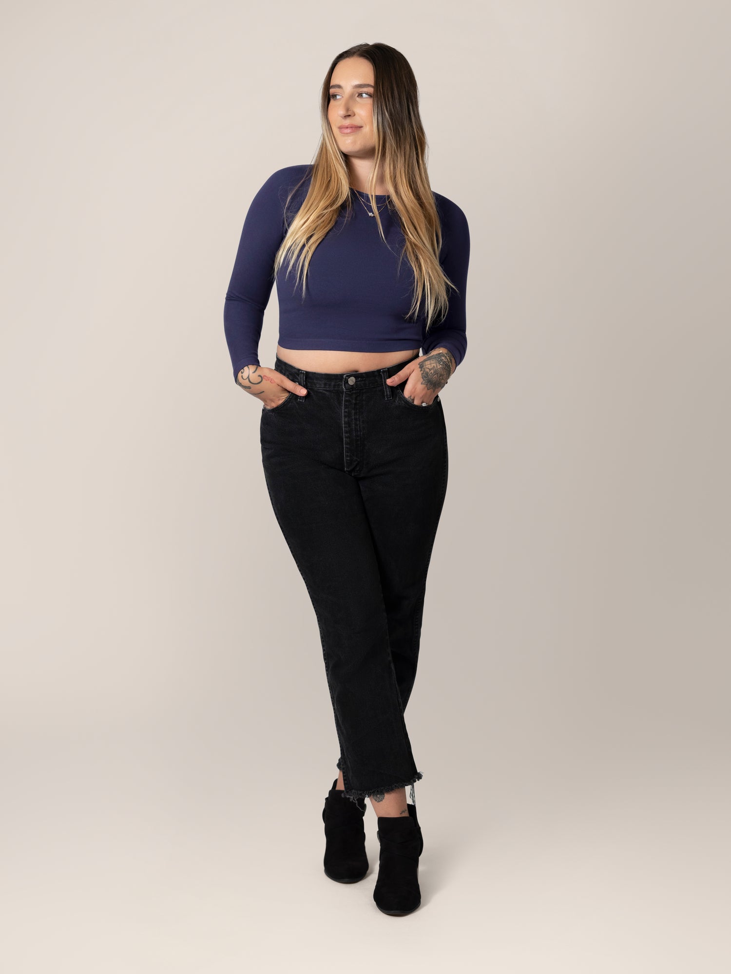 Full body view of model wearing the Sublime® Bamboo Maternity & Nursing Cropped Long Sleeve Top in Navy, paired with black cropped jeans with raw hem, and black booties