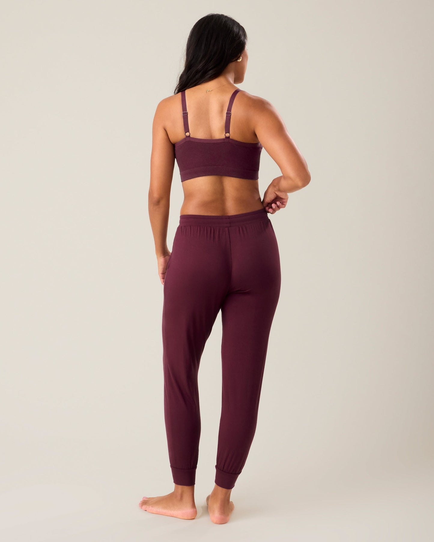 Back of woman wearing the Everyday Lounge Jogger in deep burgundy paired with matching bra
