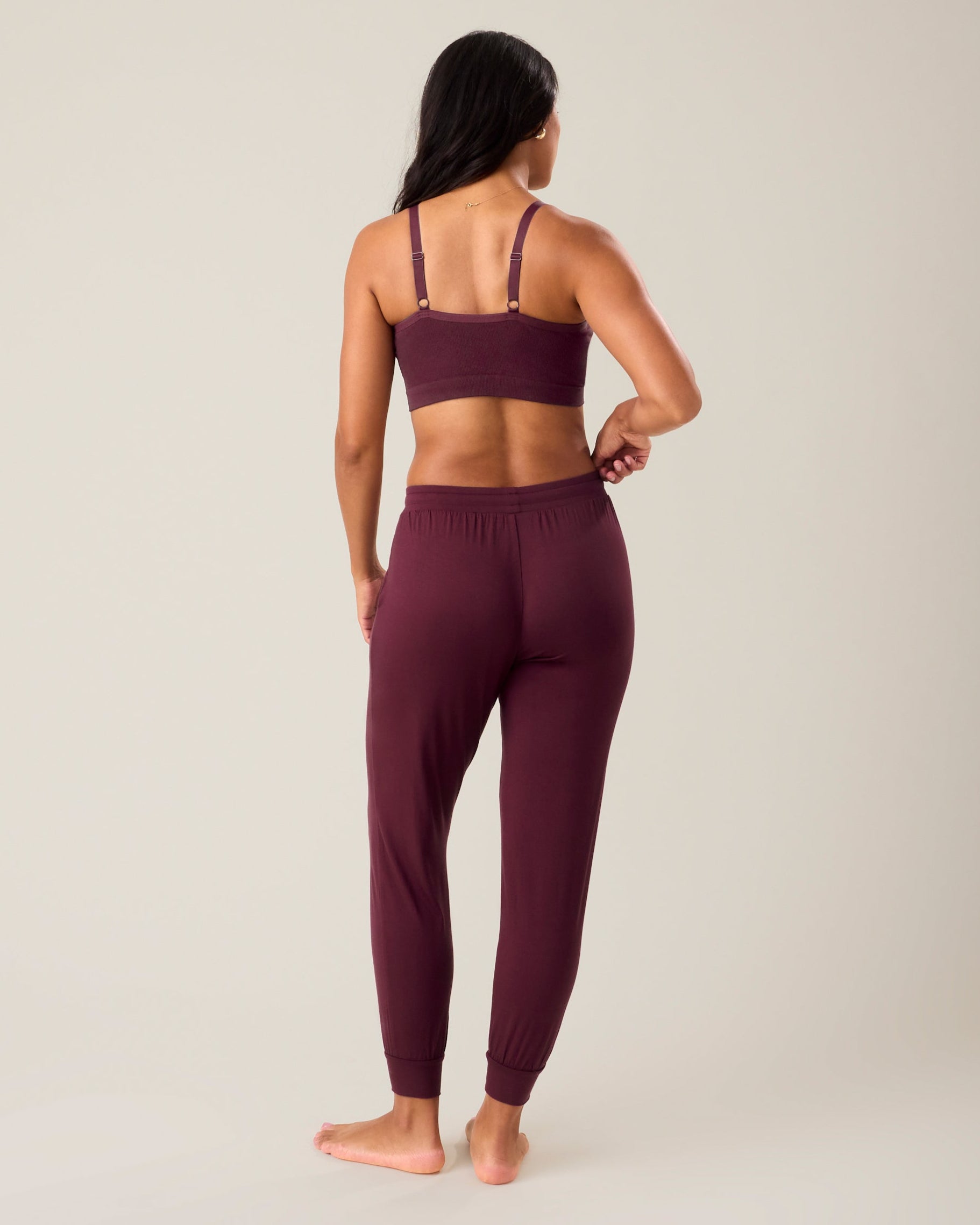 Back of woman wearing the Everyday Lounge Jogger in deep burgundy paired with matching bra