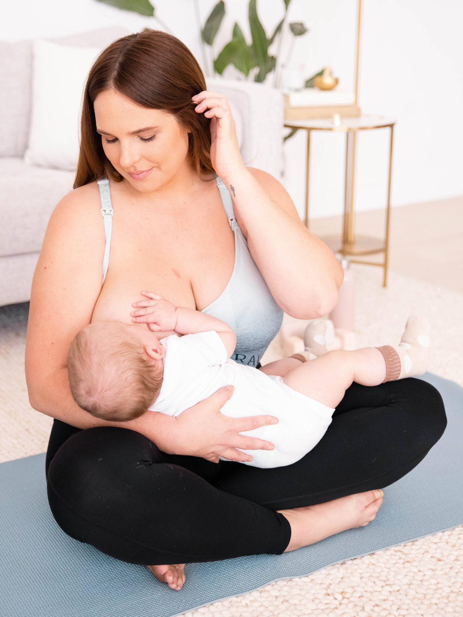 Breastfeeding model wearing the Sublime® Nursing Sports Bra in ombre storm