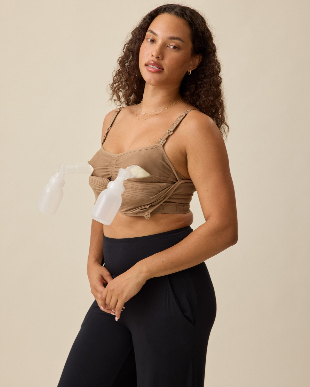 Model in the Sublime® Hands-Free Pumping & Nursing Bra in Latte with standard pumps on neutral background.