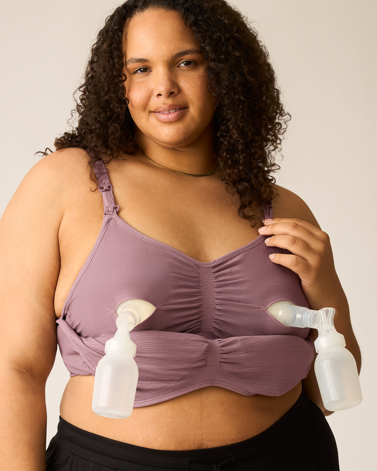 Woman wearing the Sublime® Hands-Free Pumping & Nursing Bra in Twilight with two pump flanges attached, against a plain background@model_info:Ionna is wearing a 1X Busty.