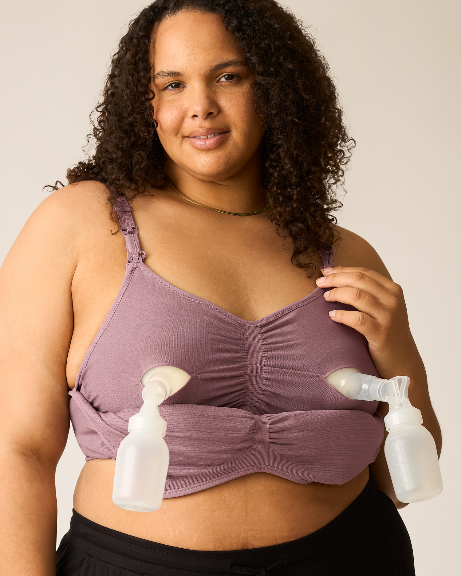 Woman wearing the Sublime® Hands-Free Pumping & Nursing Bra in Twilight with two pump flanges attached, against a plain background@model_info:Ionna is wearing a 1X Busty.