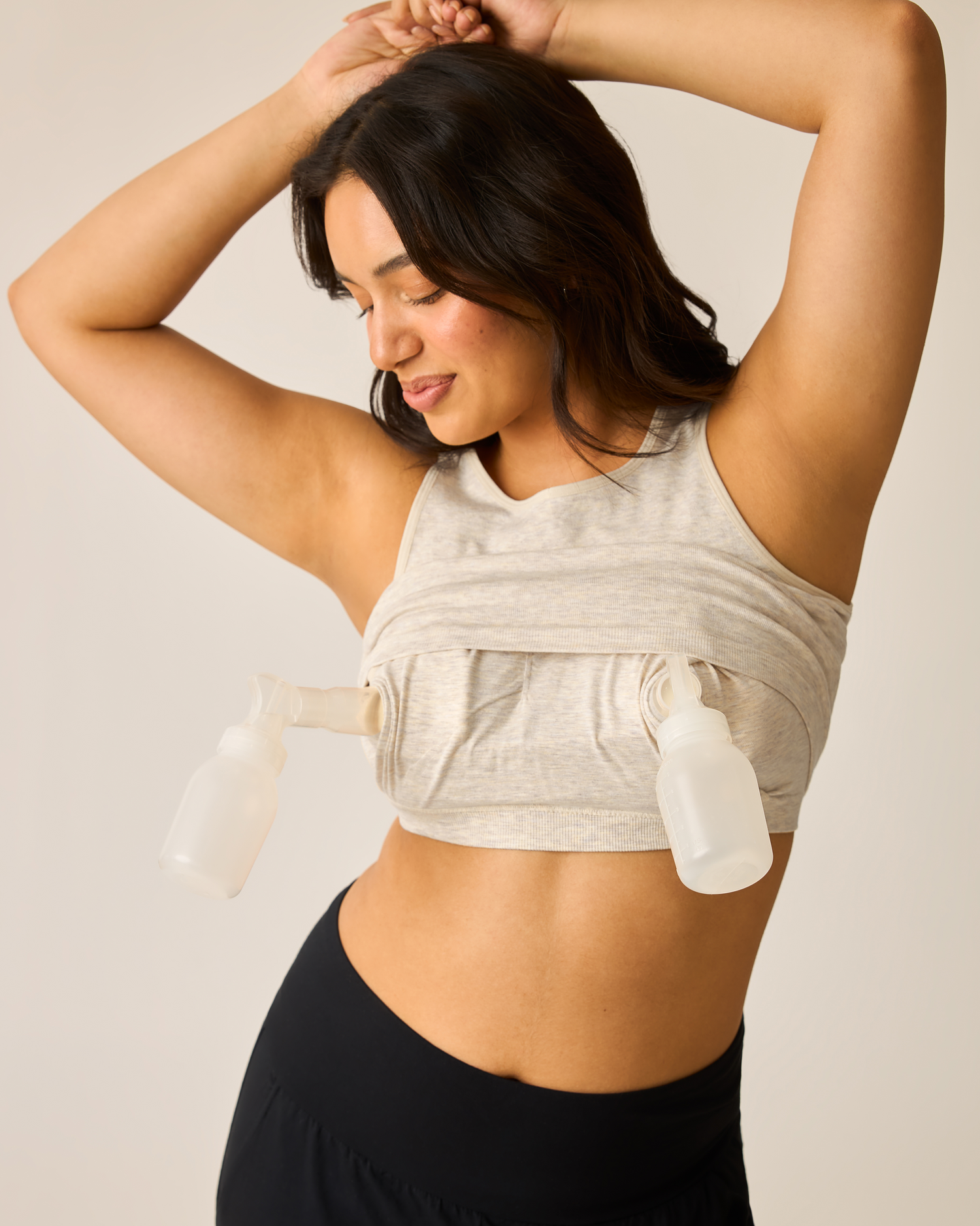 Person wearing an oatmeal heather longline bra top with pump flanges @model_info:Amber is wearing a Medium