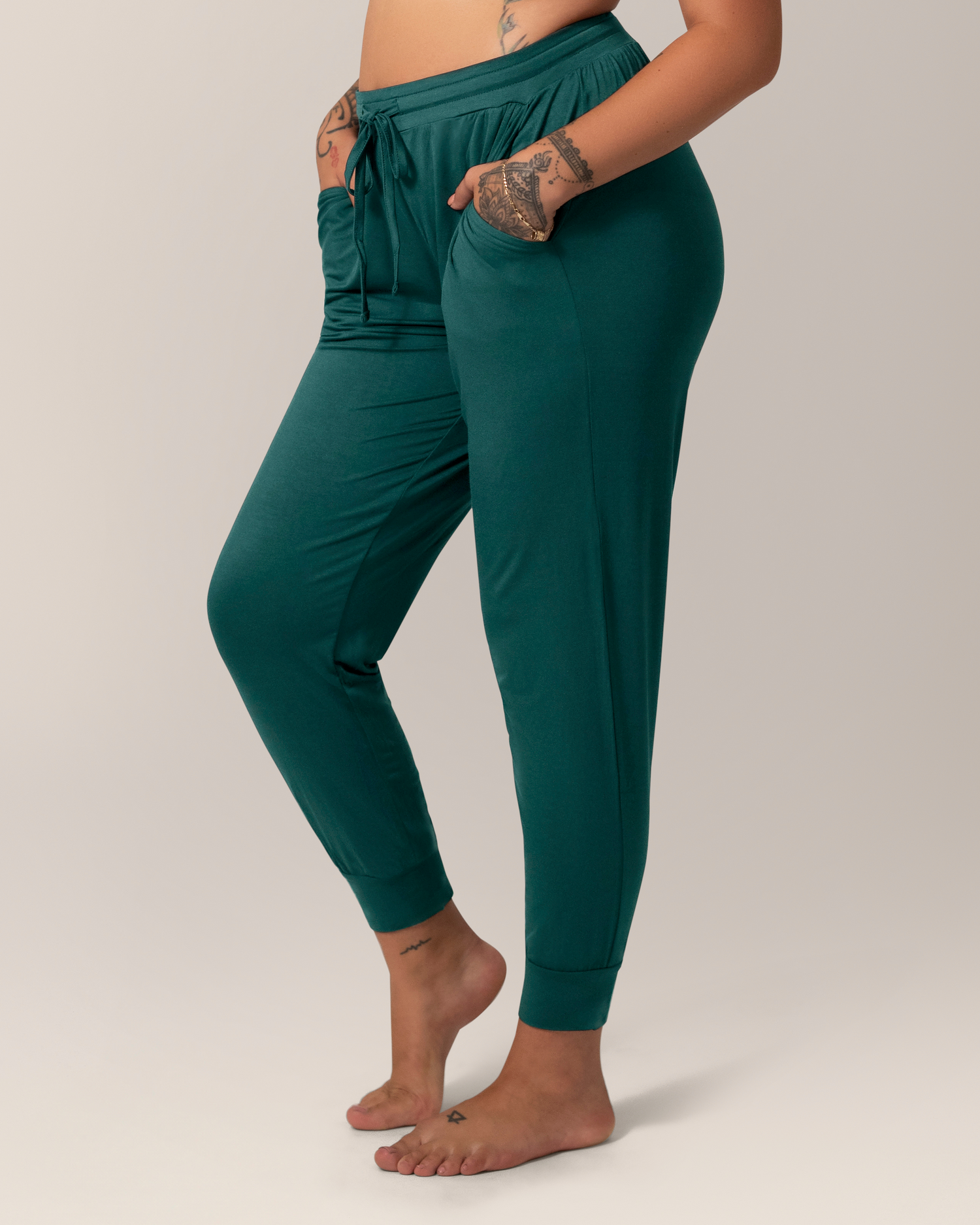 Cropped in side view of model wearing the Everyday Lounge Jogger in Evergreen, with hands in pockets
