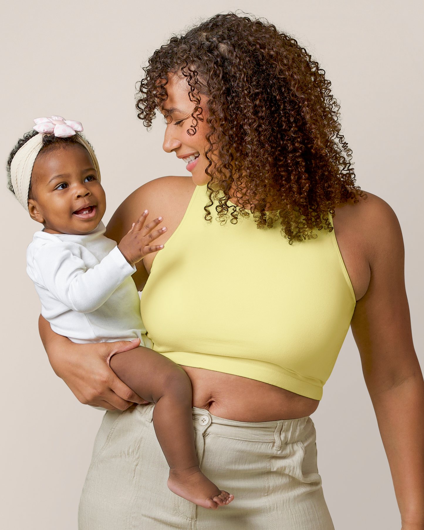 Front view of model holding baby and wearing the Sublime® Bamboo Maternity & Nursing Longline Bra Top in Light Lemon @model_info:Alysha is wearing a Large.