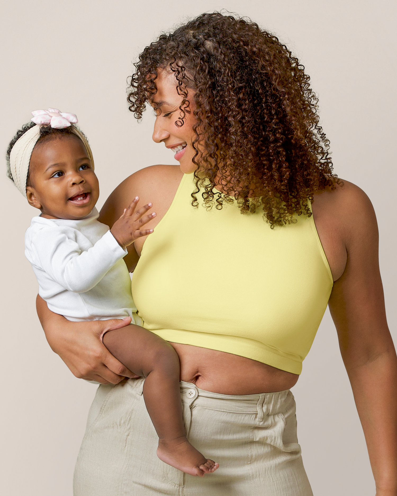 Front view of model holding baby and wearing the Sublime® Bamboo Maternity & Nursing Longline Bra Top in Light Lemon @model_info:Alysha is wearing a Large.