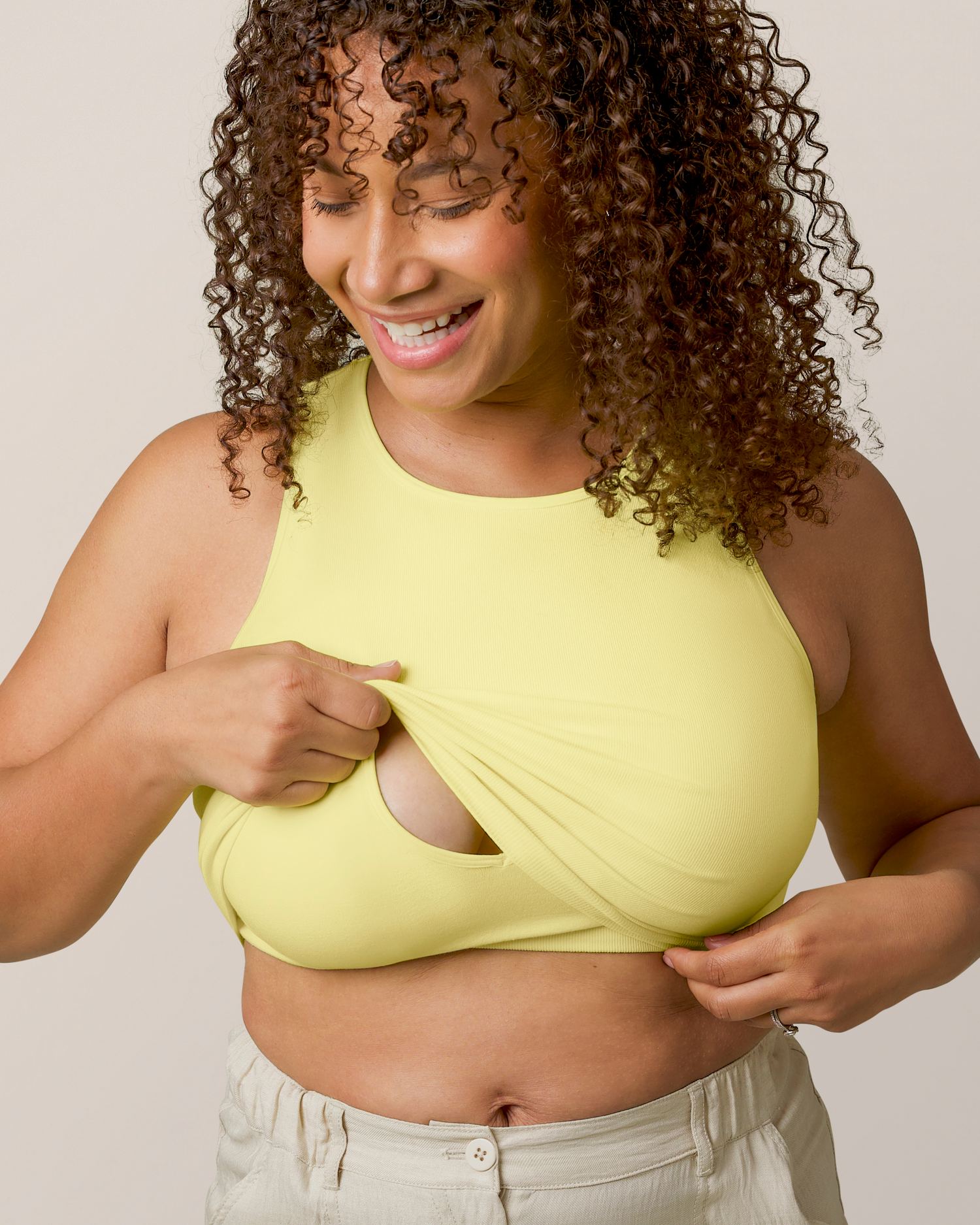 Front view of model wearing the Sublime® Bamboo Maternity & Nursing Longline Bra Top in Light Lemon, lifting outer layer to show nursing access