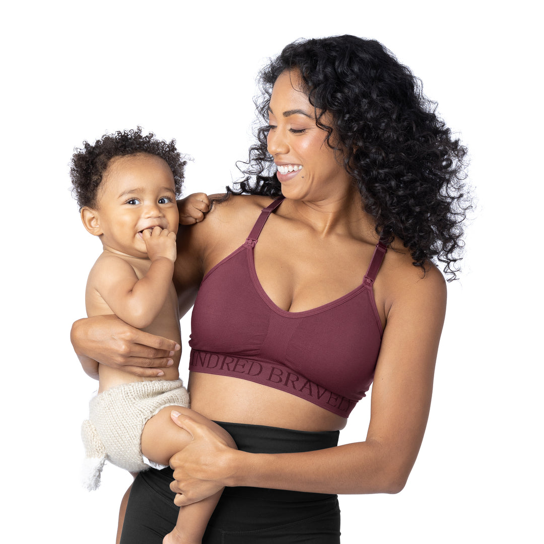 Model wearing the Sublime® Hands-Free Pumping & Nursing Sports Bra with her baby on her hip. @Model_info:Anastacia is wearing a Medium.