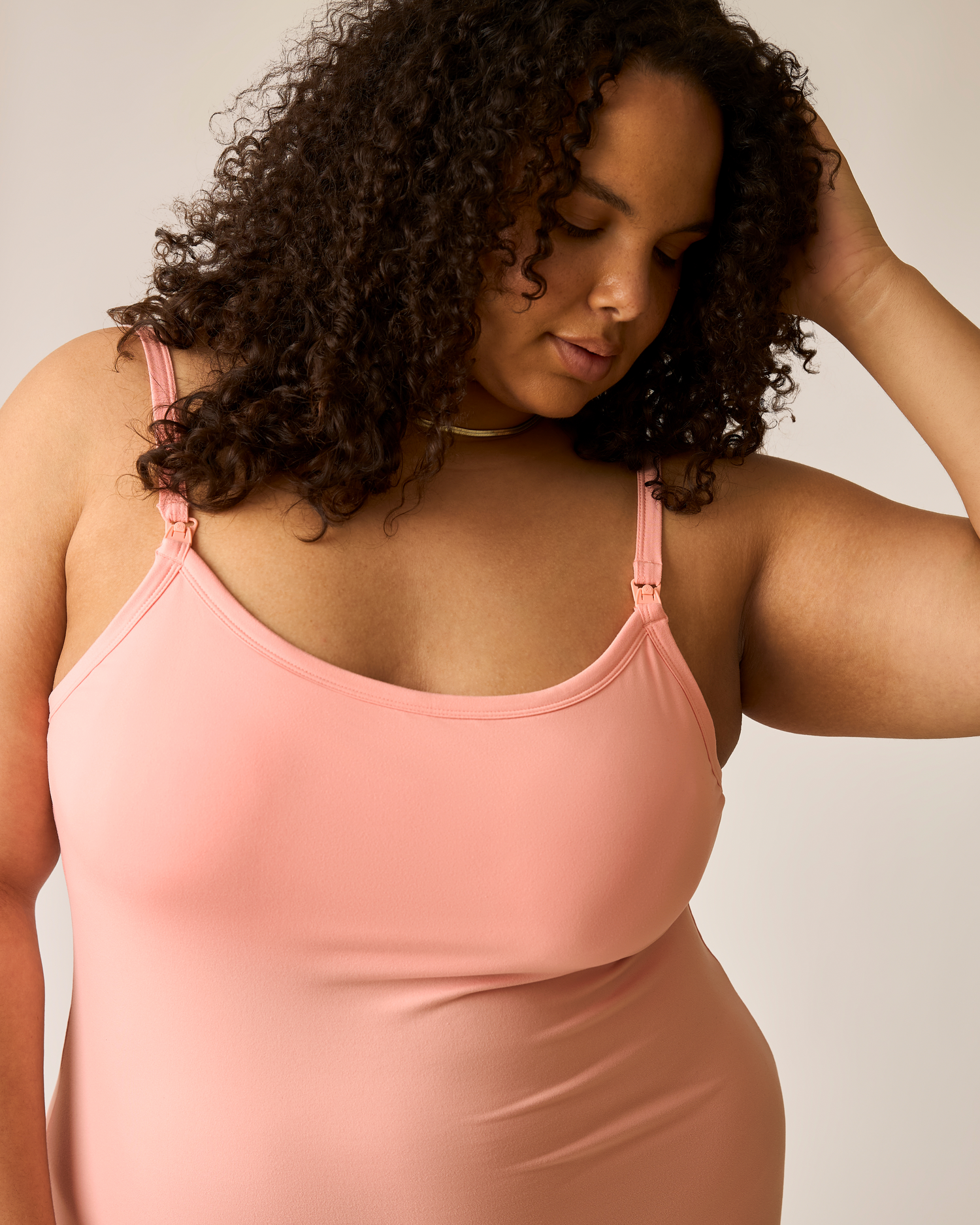 Woman wearing a pink nightgown against a neutral background