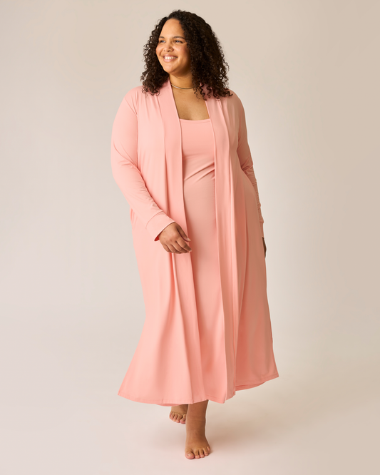 Woman wearing a pink lounge dress and matching long cardigan on a plain background@model_info:Ionna is 5'11" and wearing a 2X.