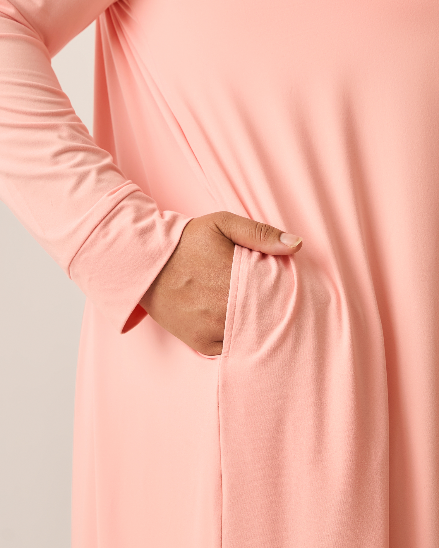 Close-up of a pink long-sleeve duster top with a pocket.