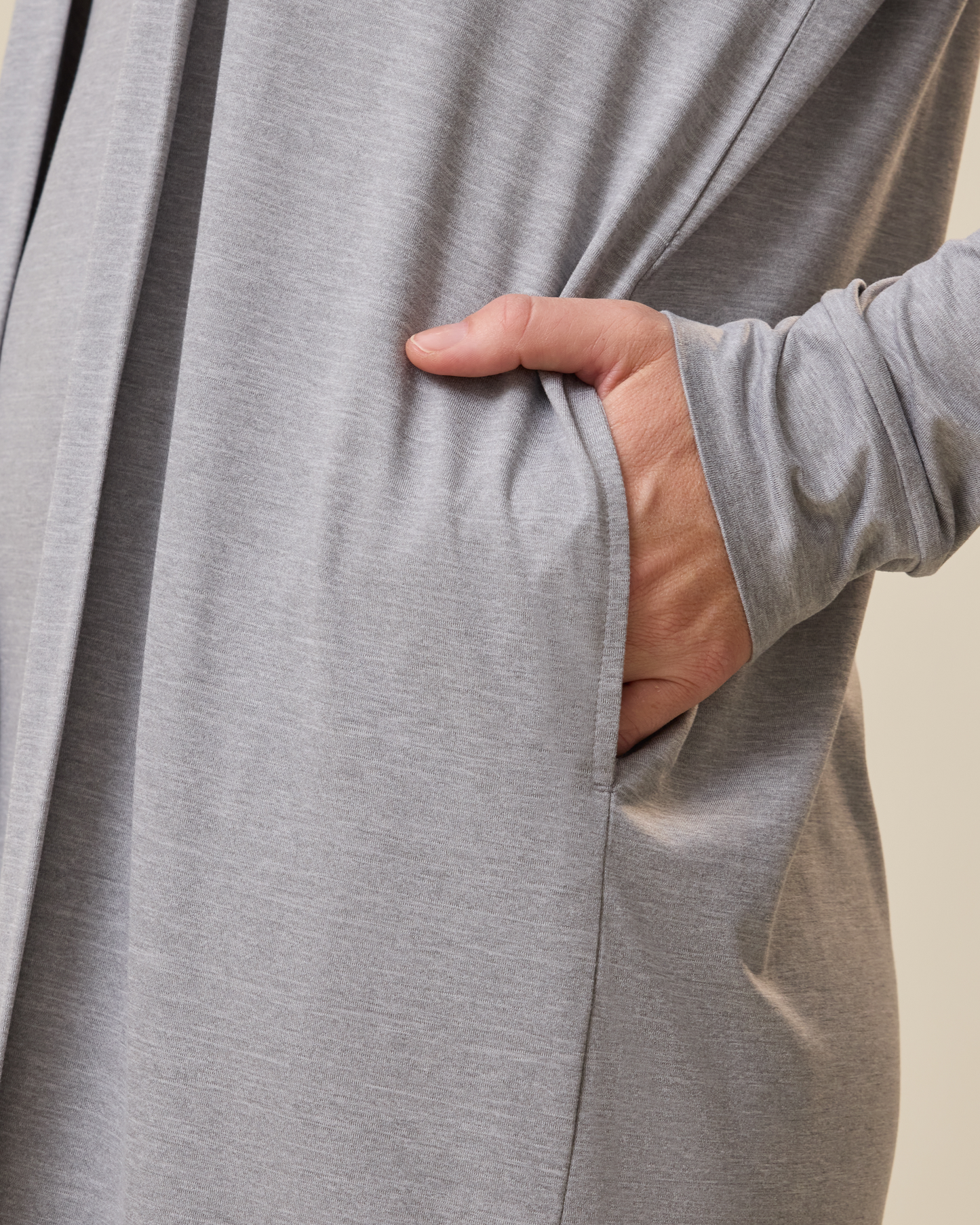 Person wearing a gray long-sleeve duster with a hand in the pocket against a beige background@model_info:Lauren is 5'8" and wearing a Medium.