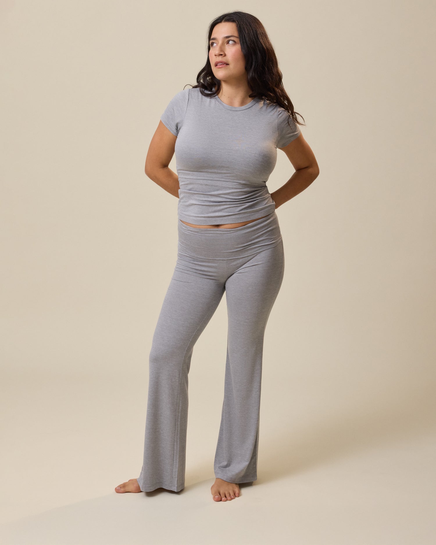 Woman wearing a gray lounge outfit on a beige background@model_info:Linda is 5'4" and wearing a Small.