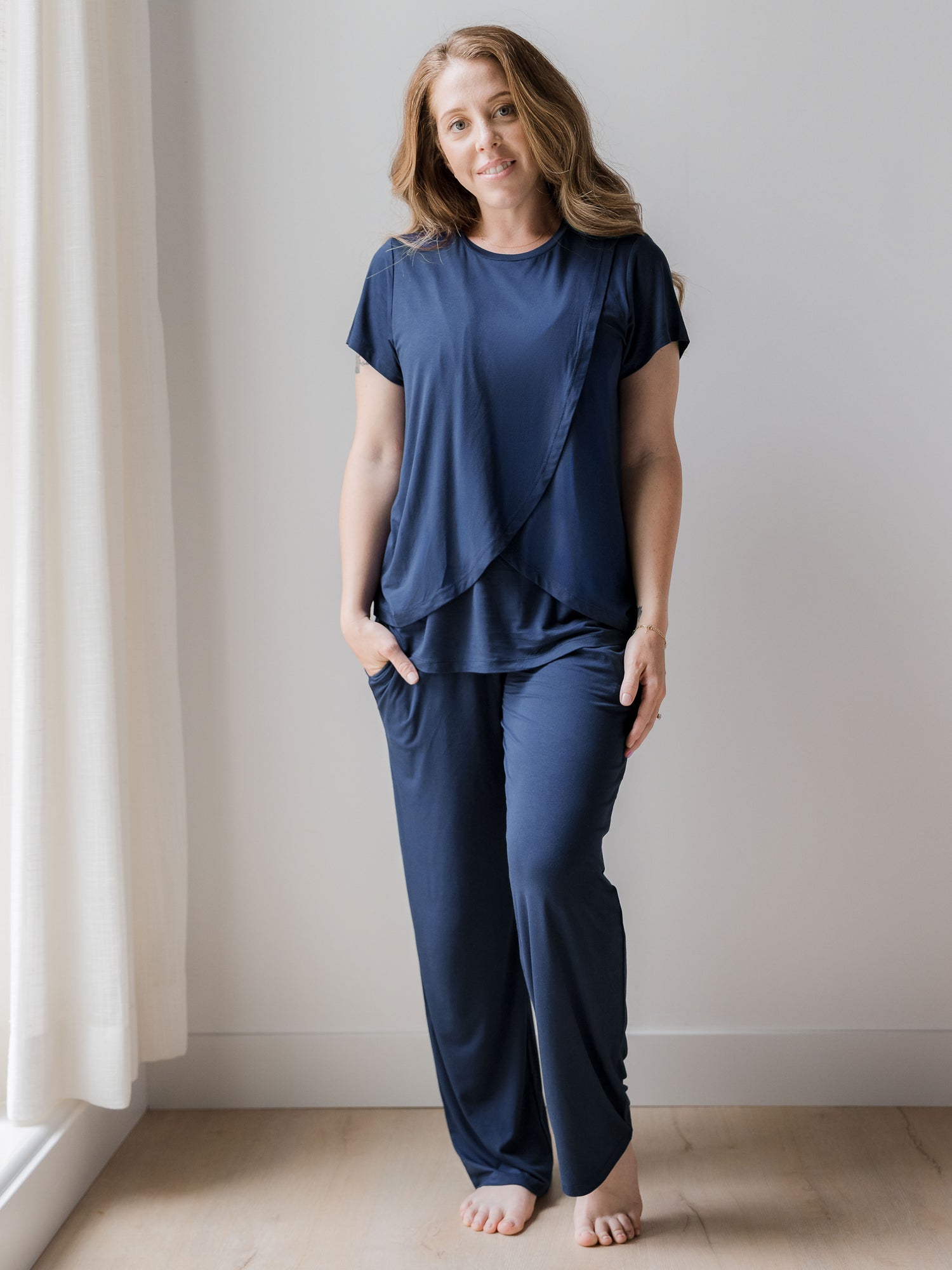 Model wearing a Short Sleeve Tulip Hem Maternity Pajama set - Top & Bottom in Navy Blue. @model_info: Ashley is wearing a Small.