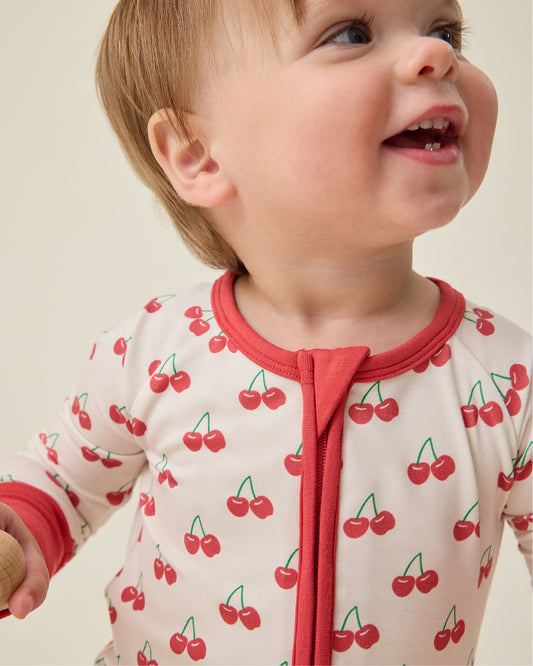 Baby wearing the Bamboo Baby Pajama in Ivory Cherries pattern