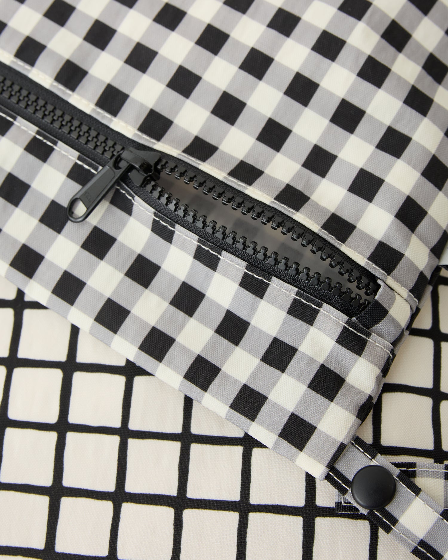Close up on the zipper and patterns of the Wet/Dry Bag Set in Black Grid.
