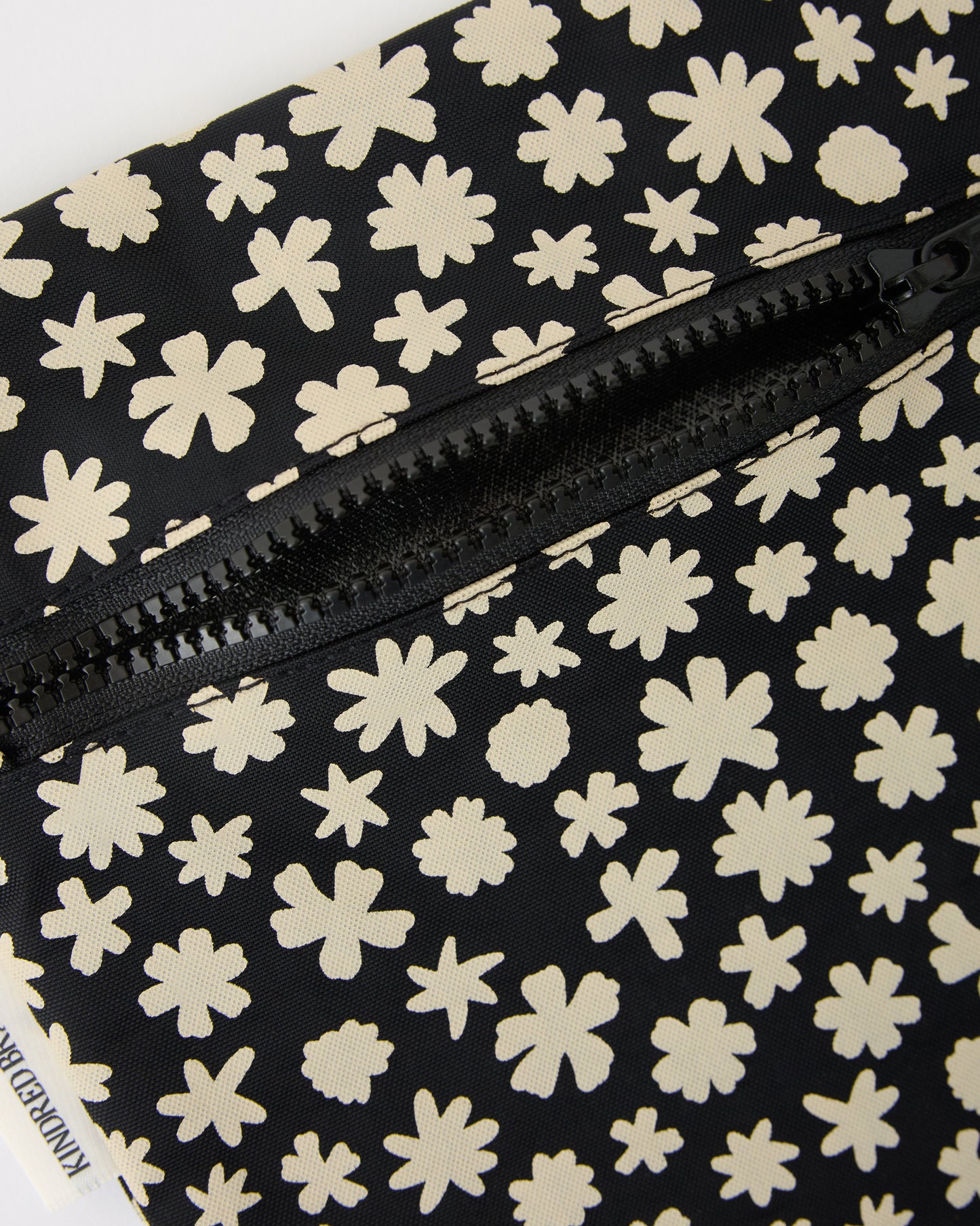 Close up of zipper on Wet/Dry Bag Set in Cream Chamomiles on a beige background