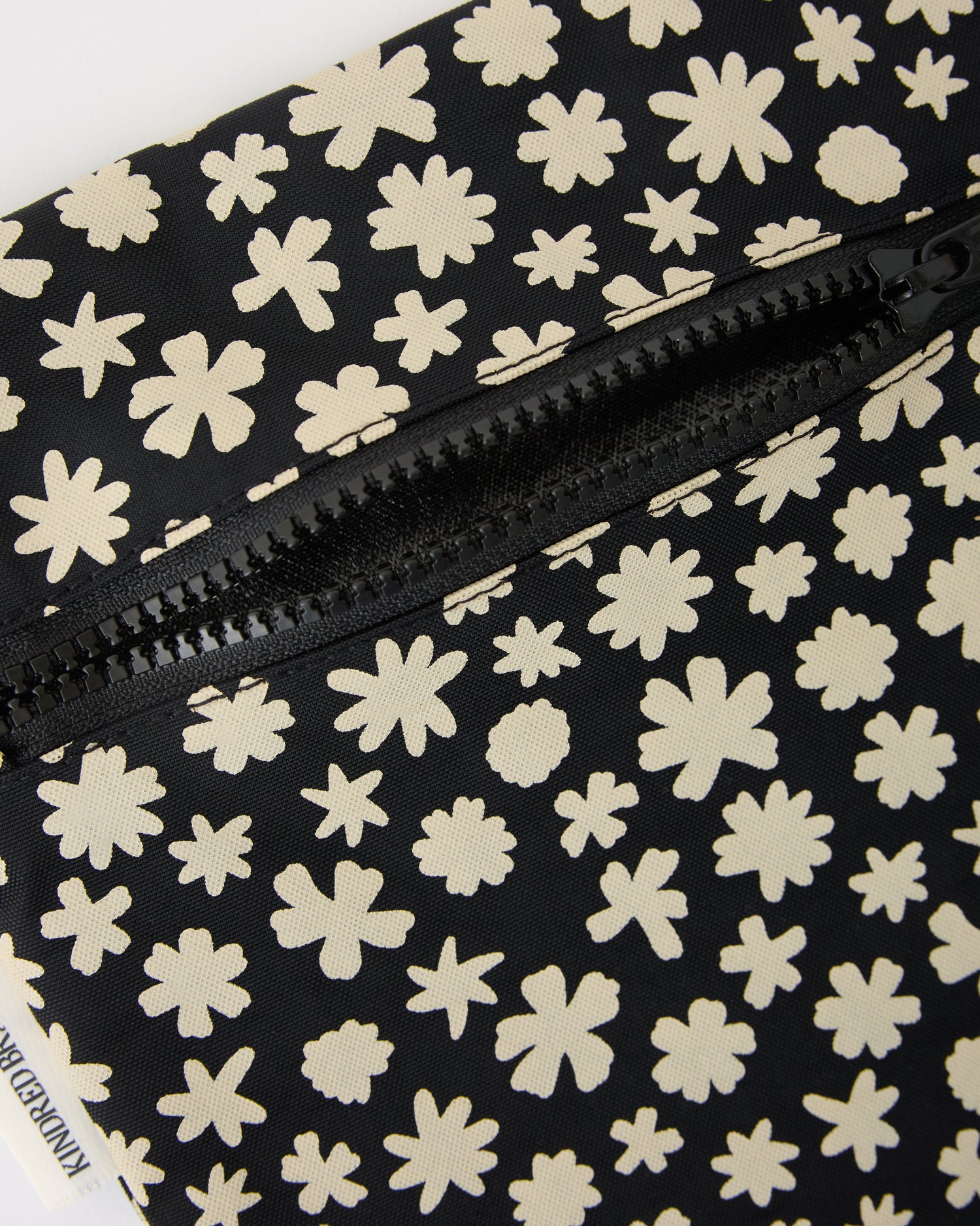 Close up of zipper on Wet/Dry Bag Set in Cream Chamomiles on a beige background