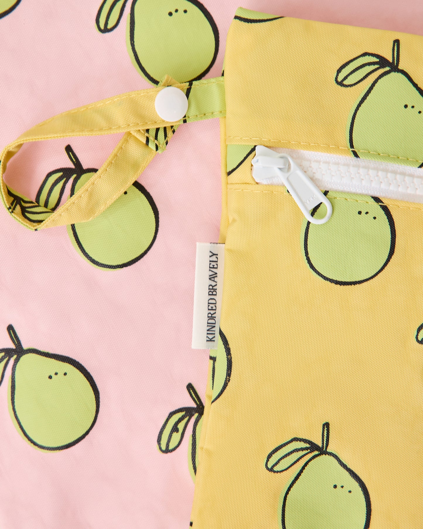 Close up of Wet/Dry Bag Set in Pomelo print, to display zipper and strap snap button for easy organization