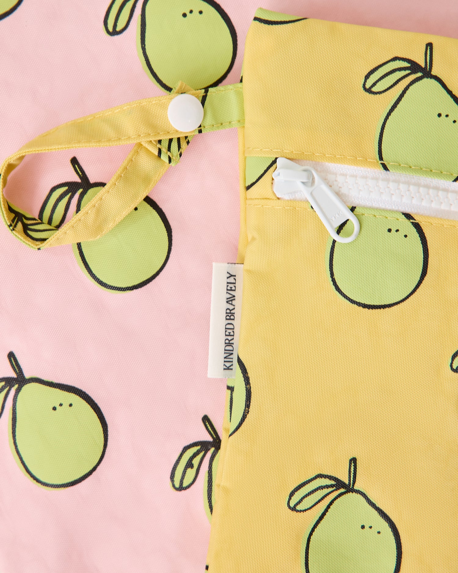 Close up of Wet/Dry Bag Set in Pomelo print, to display zipper and strap snap button for easy organization