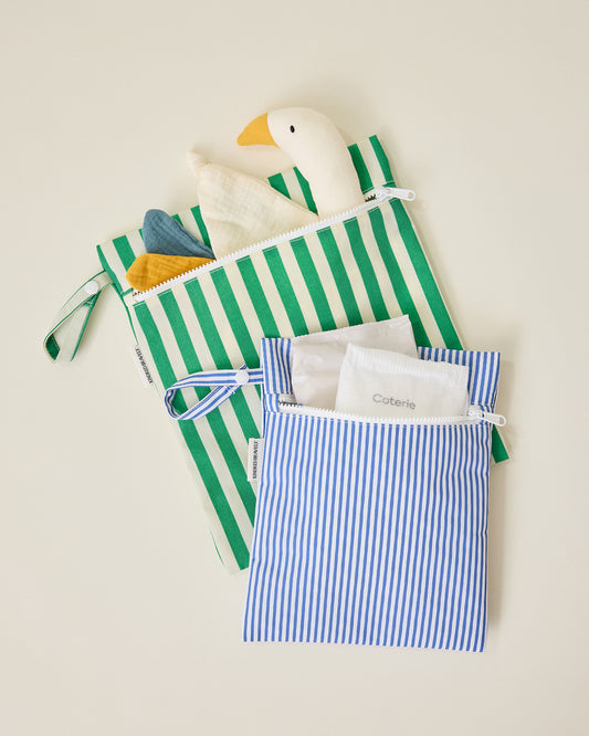 Wet/Dry Bag Set in Stripe print holding a duck lovey in the large green stripe bag and a diaper with wipes in the small blue stripe bag on beige background