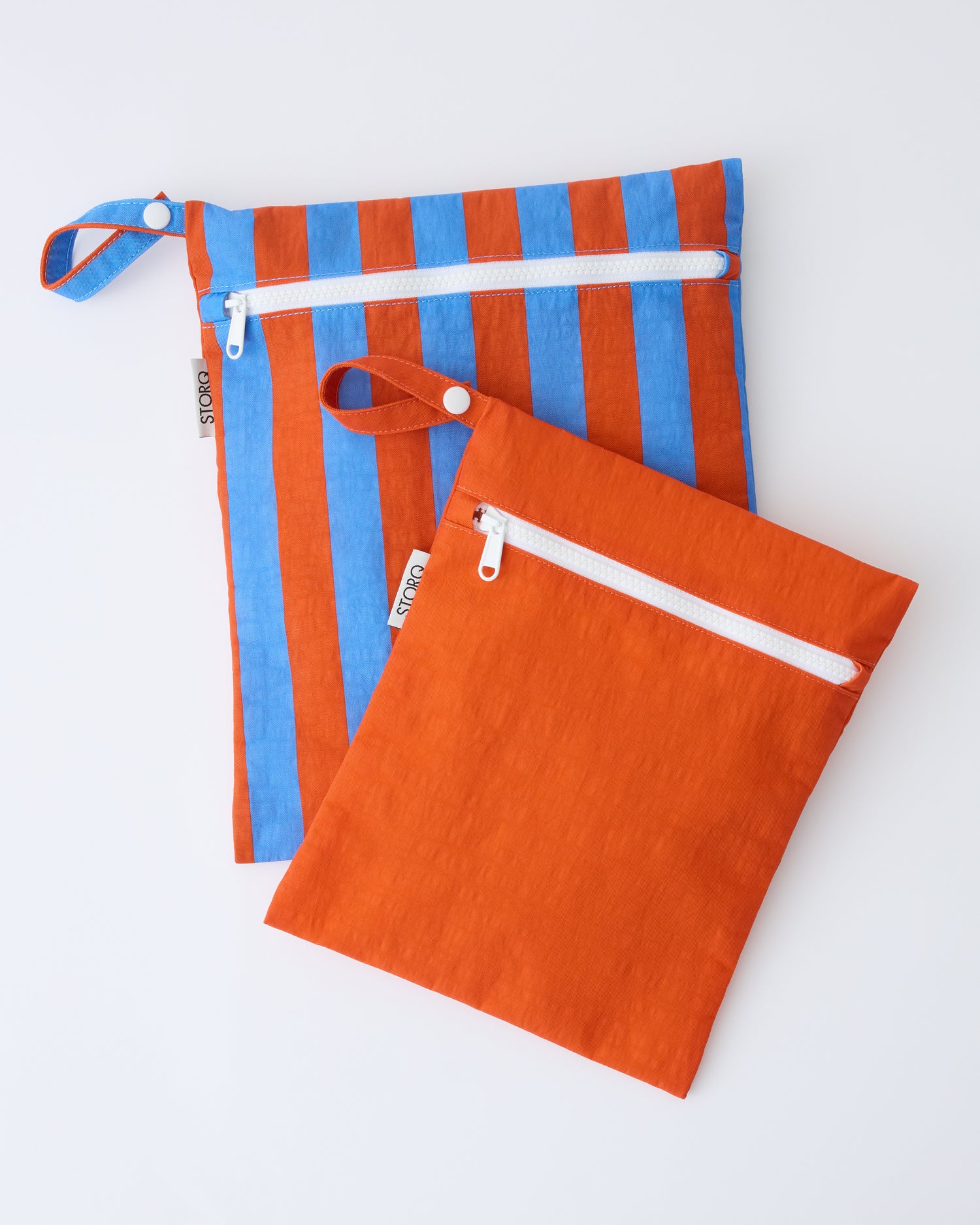 Wet/Dry Bag Set in Blue & Rust Stripe on a beige background.