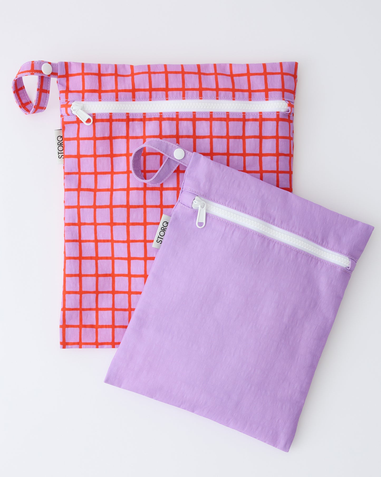 Wet/Dry Bag Set in Orchid Grid on a beige background.