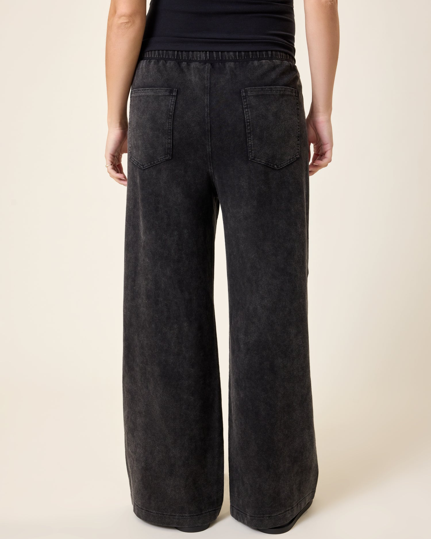 Wide Leg Maternity & Postpartum Drawstring Pant in dark wash worn by a person on a beige background