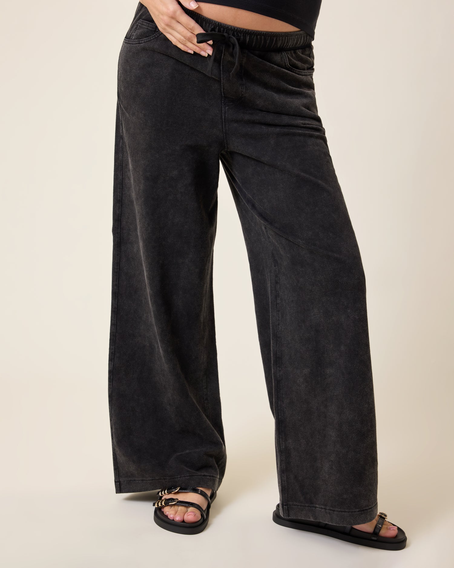 Wide Leg Maternity & Postpartum Drawstring Pant in dark wash worn by a person on a beige background@model_info:Elliana is 5'7" and wearing a Medium.