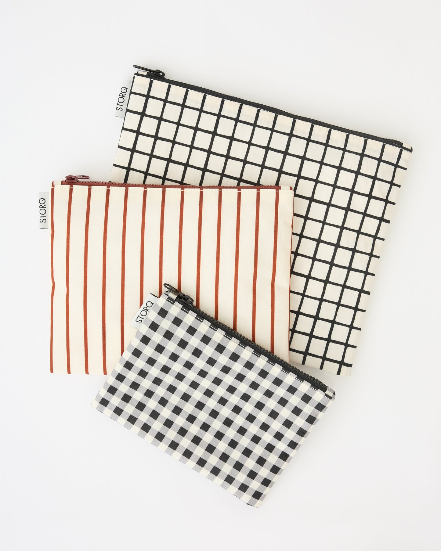 Zipper Pouch Three-Piece Set in Black Grid on a beige background.