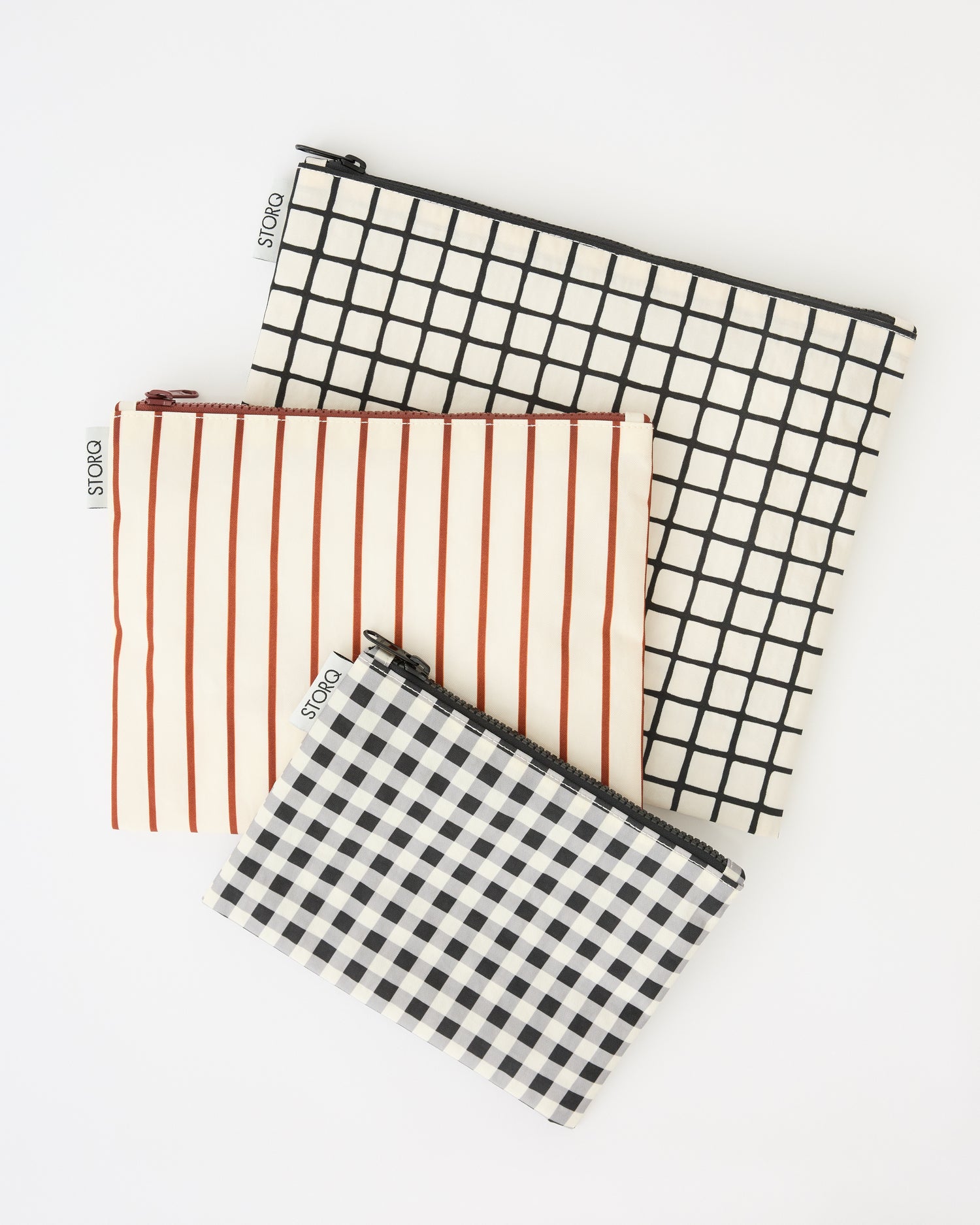 Zipper Pouch Three-Piece Set in Black Grid on a beige background.