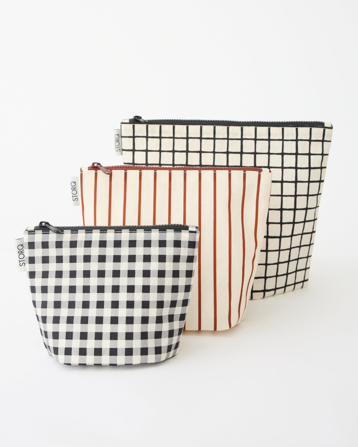 Zipper Pouch Three-Piece Set in Black Grid on a beige background.