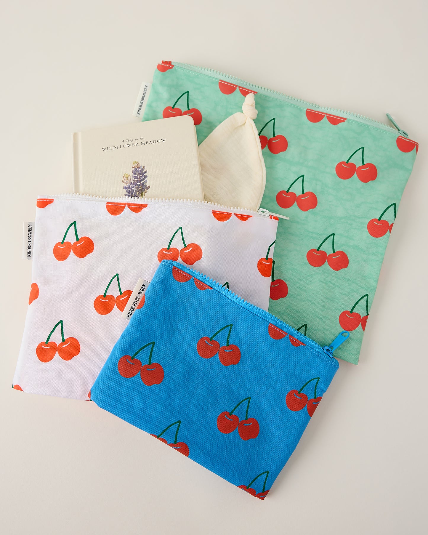 Three pouches with cherry pattern on a light background