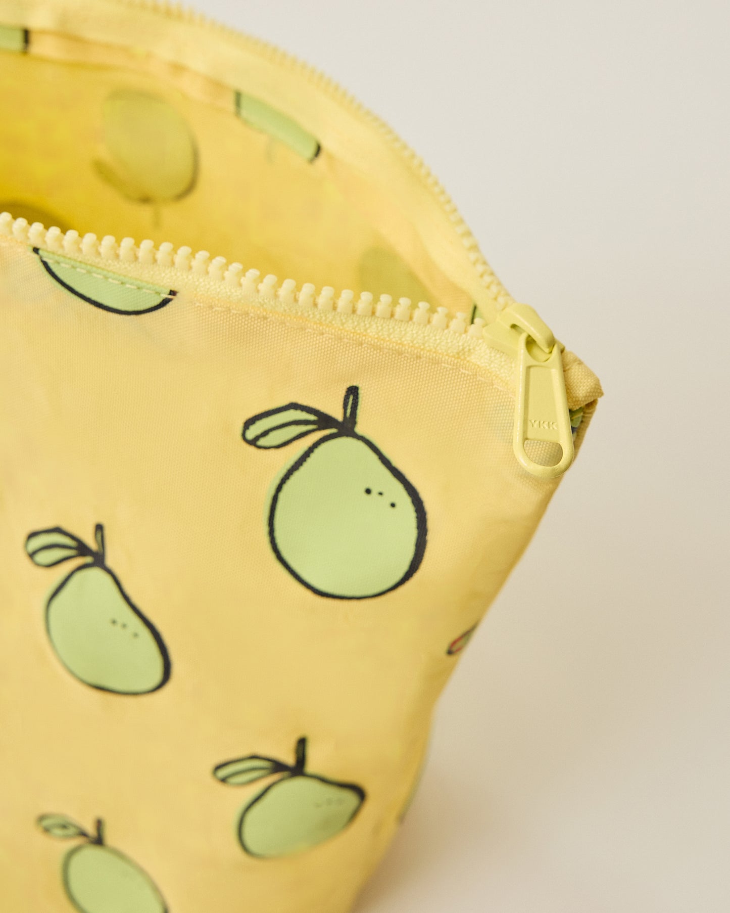Close up of the Zipper Pouch Three-Piece Set in Pomelo print on a beige background
