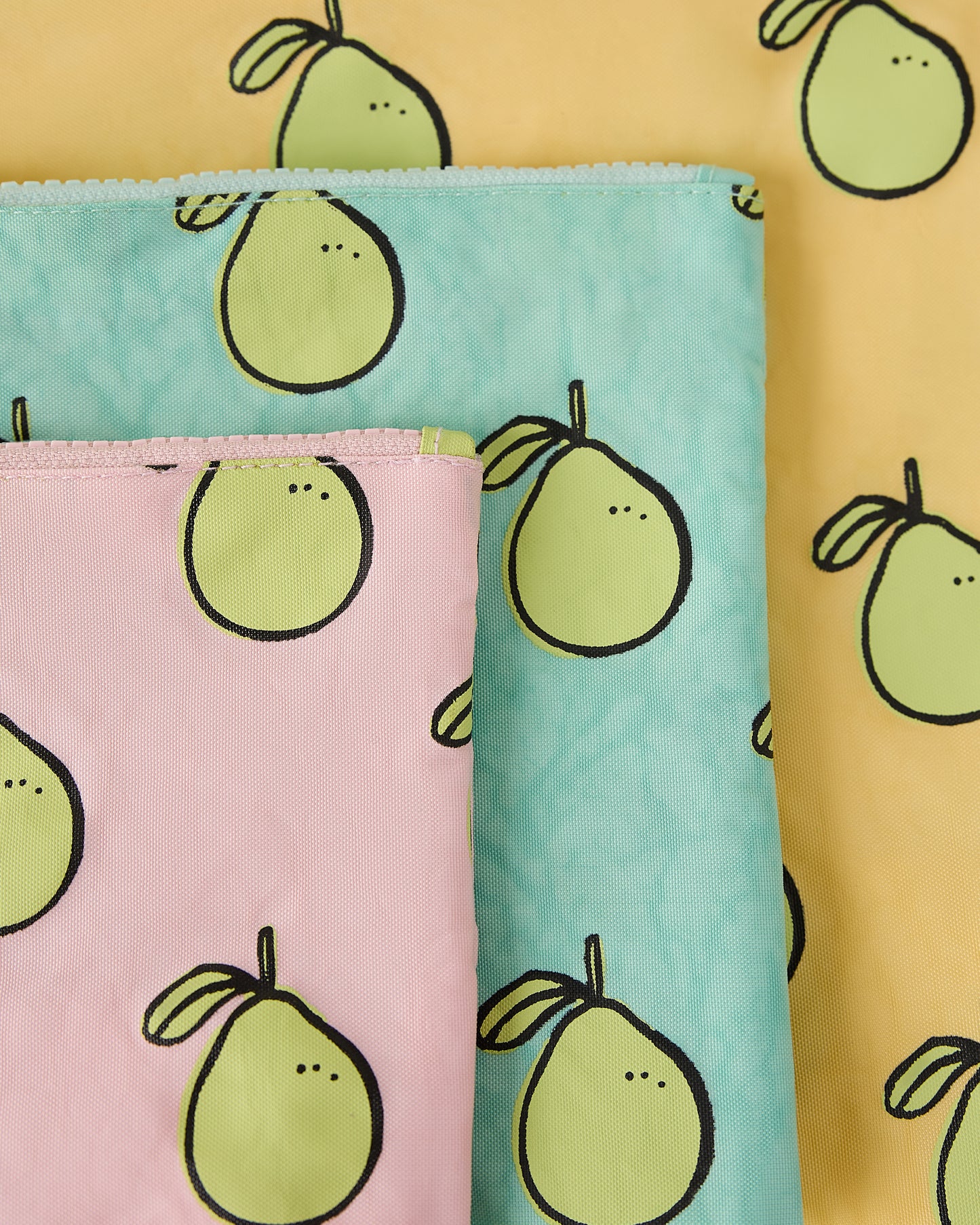 Close-up of three zipper pouches with pomelo pattern on a yellow background