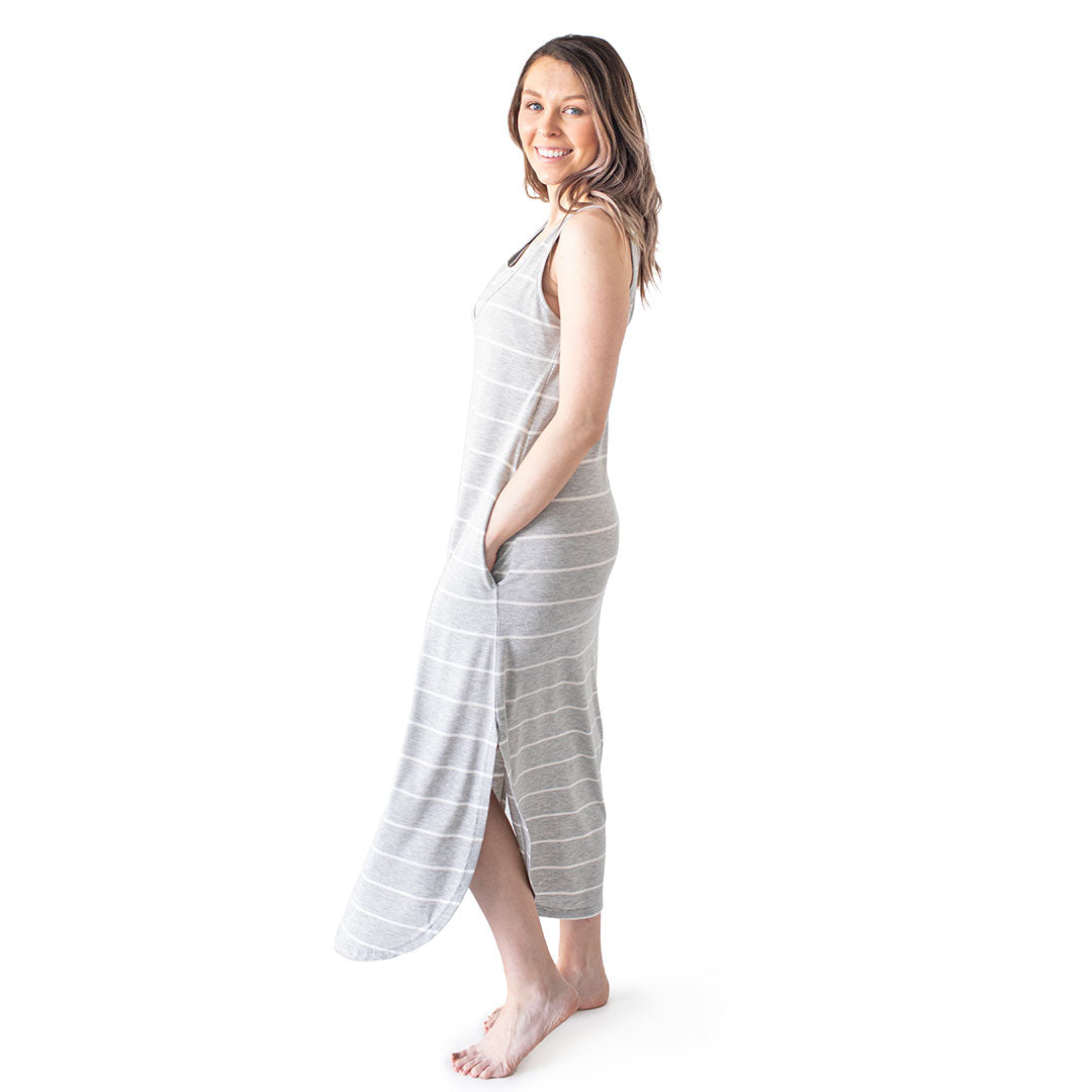 Full body view of a model wearing the Zora Maternity & Nursing Maxi Dress in Grey Heather with her hands in her pockets. @model_info:Megan is wearing a Small.