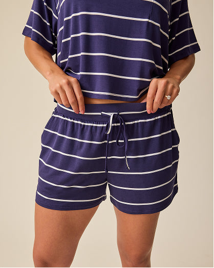 Model is wearing Aria Bamboo Casual Lounge Short in Navy & White Stripe on a beige background.@model_info:Sadie is wearing a Medium.