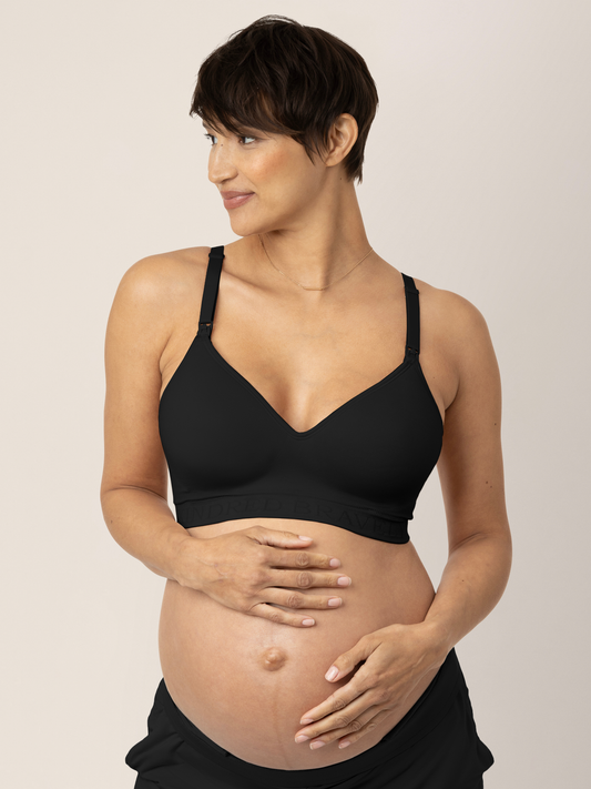 Pregnant model wearing the Signature Sublime® Contour Maternity & Nursing Bra in Black holding her baby bump @model_info:Brianna is wearing a Small.