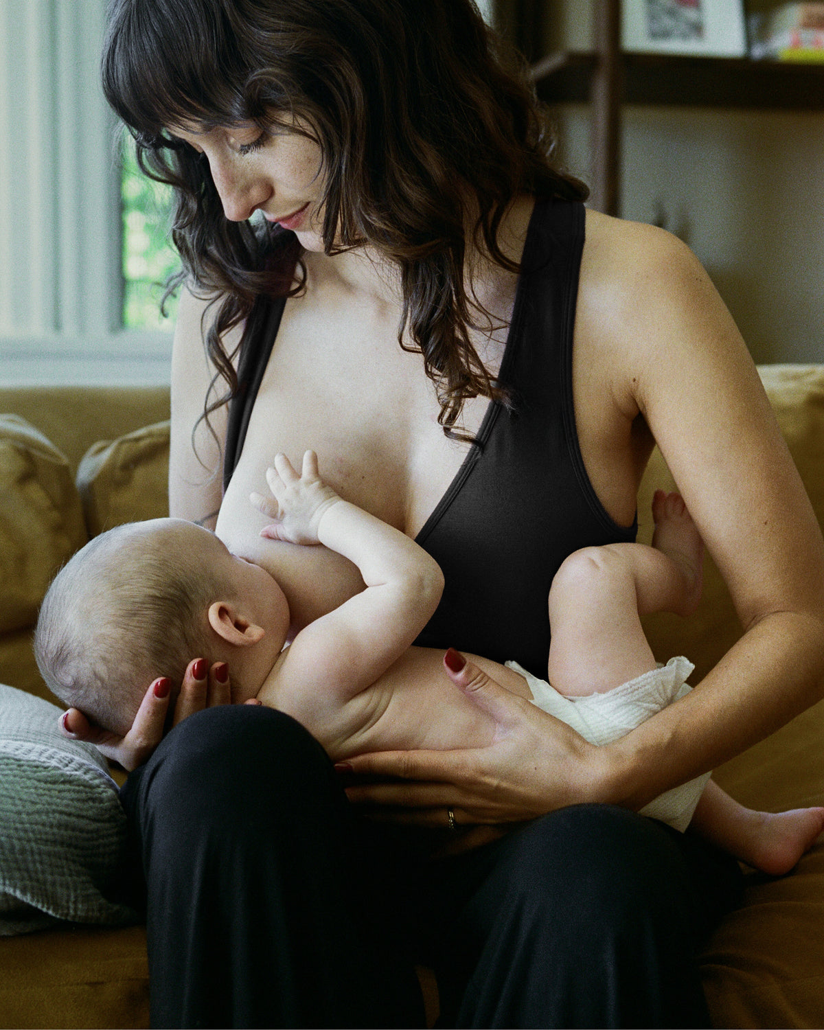 Woman wearing the French Terry Racerback Nursing & Sleep Bra in black against a neutral background@model_info:Kayla is wearing a Small Busty.