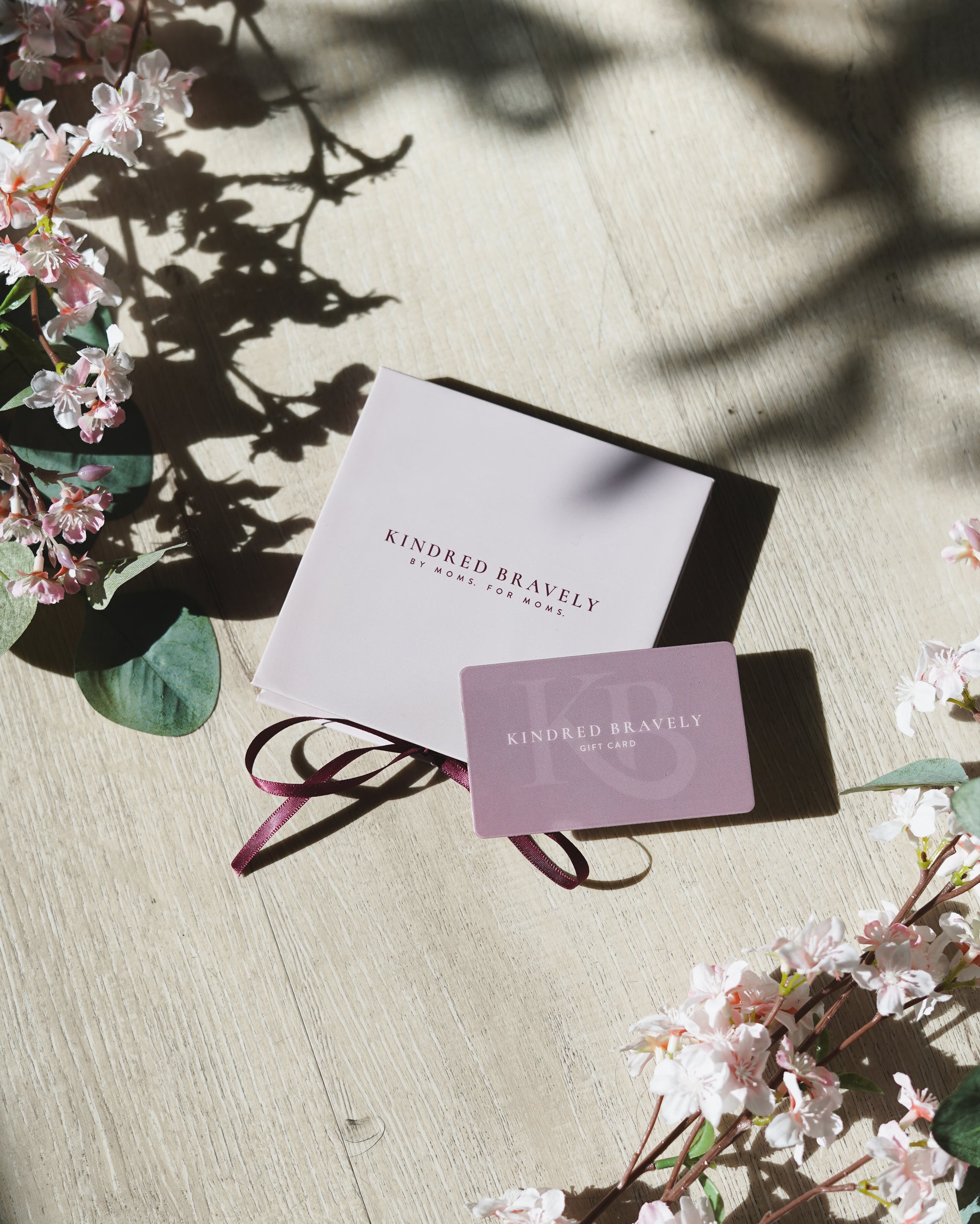 Kindred Bravely physical gift card and box, with flowers