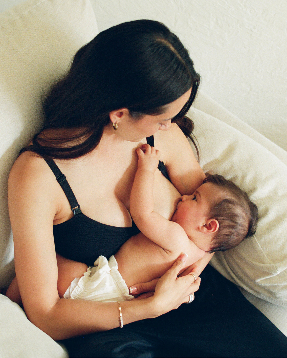 Woman wearing the Sublime® Hands-Free Pumping & Nursing Bra in black on plain background@model_info:Zoe is wearing a Small.