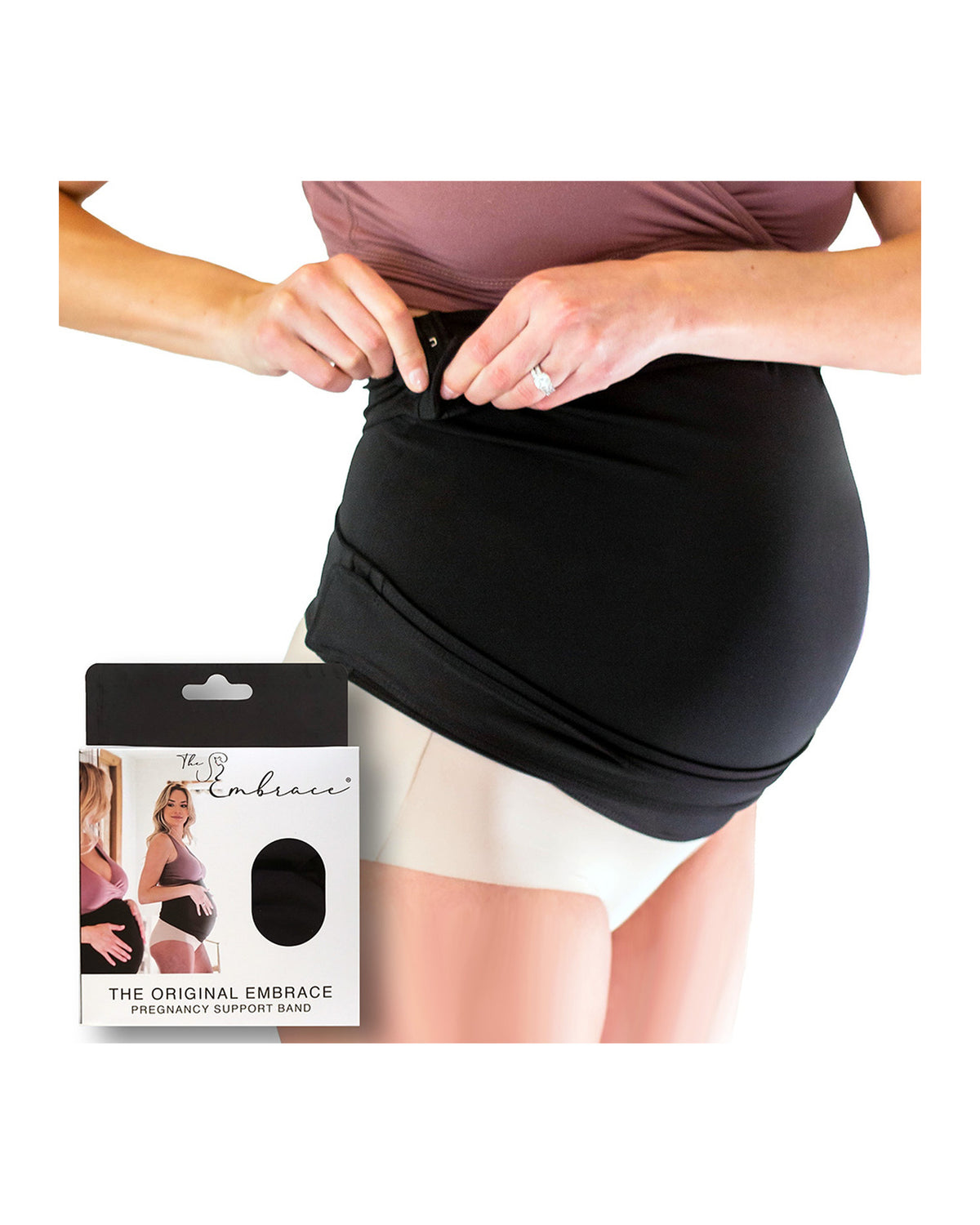 A pregnant model demonstrates how to wear the black maternity support band, The Embrace, around her baby bump. The product packaging box for 'The Embrace' is shown in the bottom-left corner against a plain white background. Box reads, The Embrace, The Original Embrace Pregnancy Support Band.