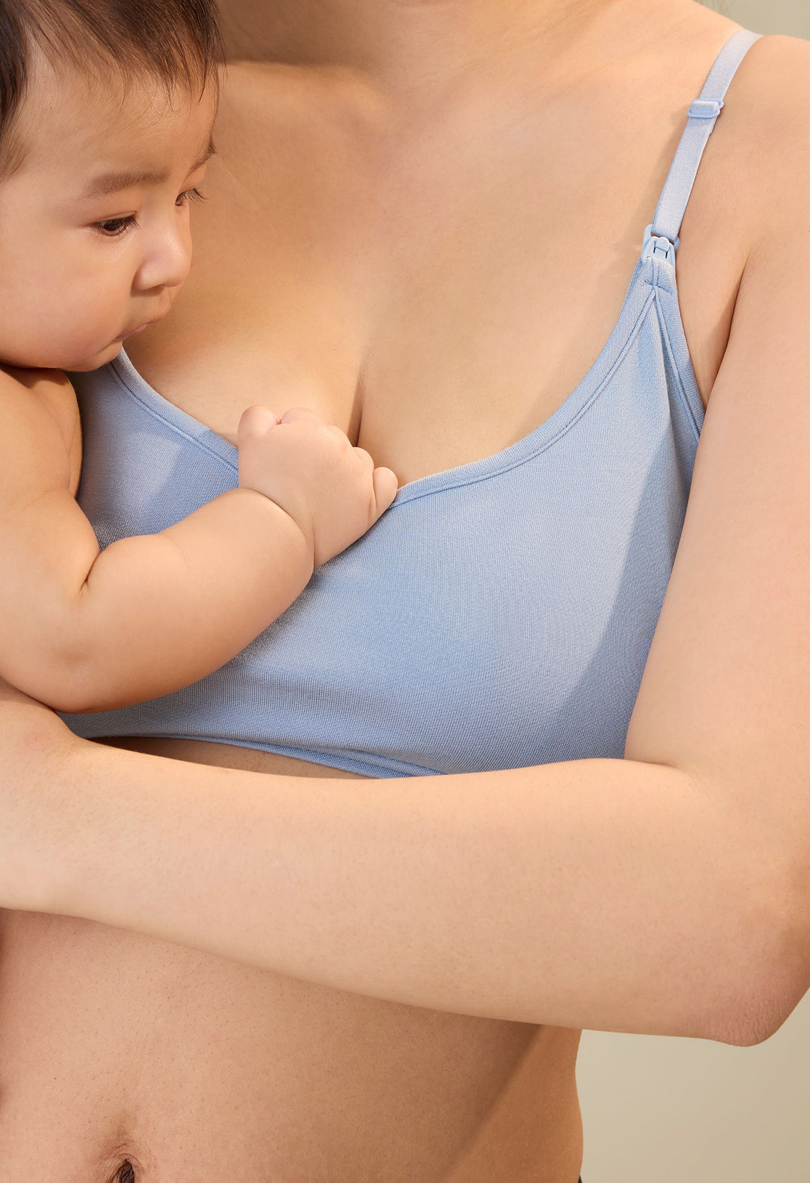 Close up of model holding a baby and wearing French Terry Maternity & Nursing Bralette in Vintage Blue